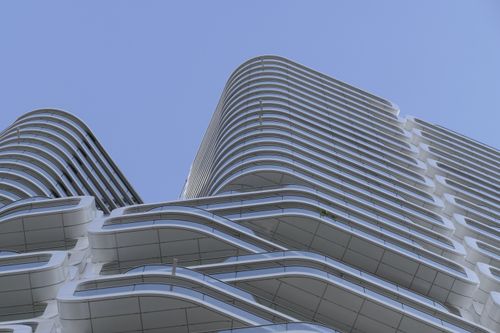 Free A futuristic building facade with clean lines and curves under a clear blue sky in Frankfurt. Stock Photo