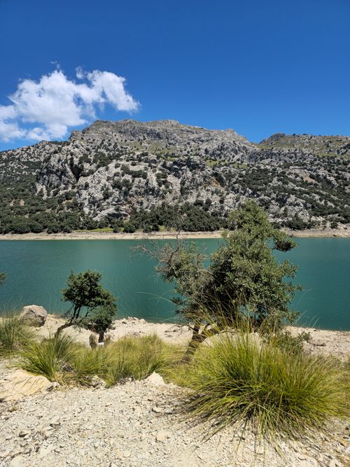 Free A serene mountain landscape with a crystal-clear lake under a bright blue sky, perfect for nature enthusiasts. Stock Photo