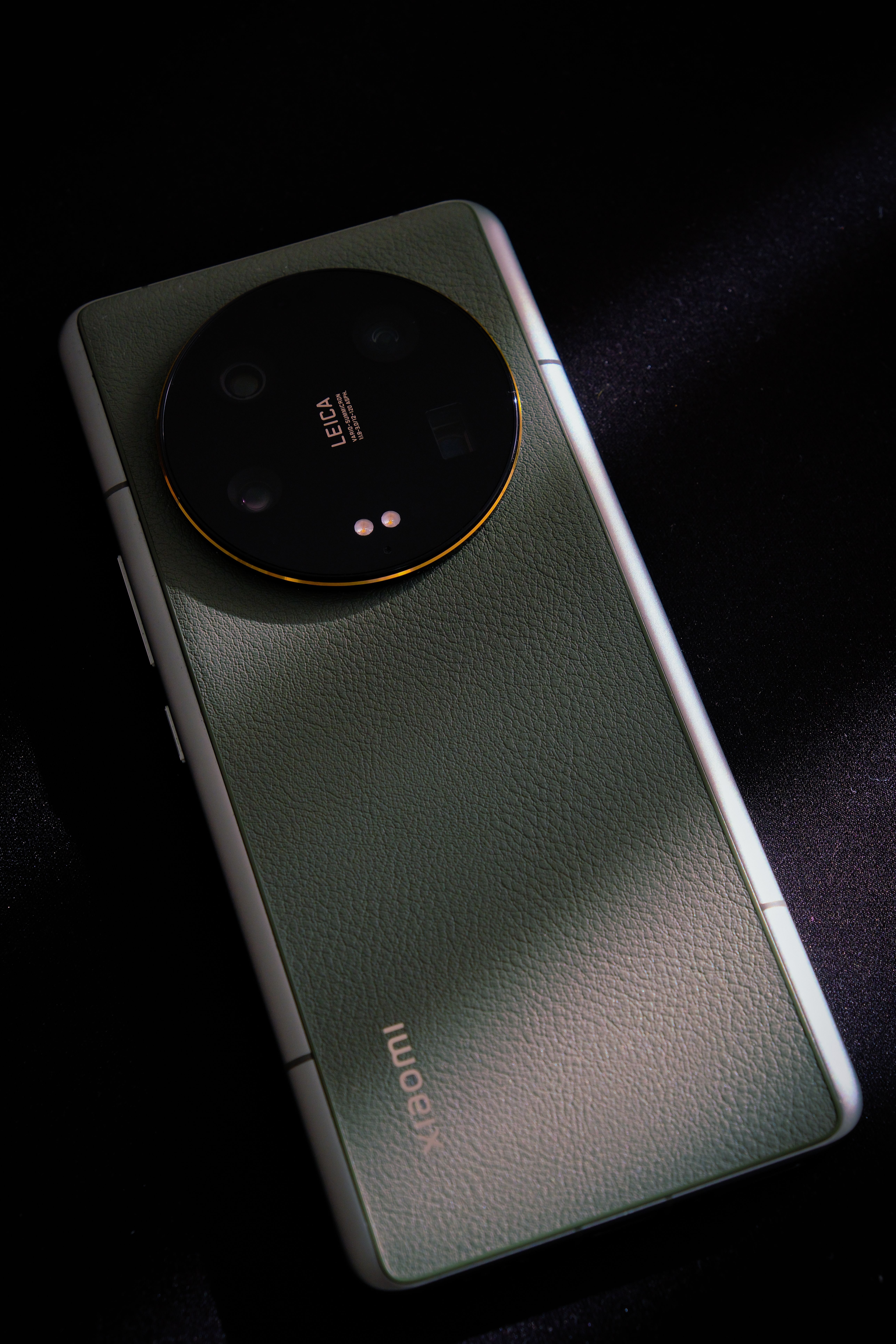 A sleek smartphone with a leather finish showcased in dark, dramatic lighting.