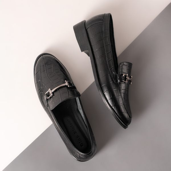 Black leather loafers on a grey and white background — photo by José Martin Segura Benites on Pexels