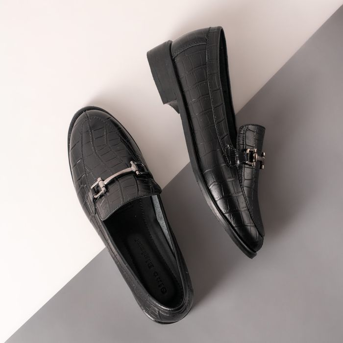 Black textured leather loafers on a grey and white backdrop — photo by José Martin Segura Benites on Pexels