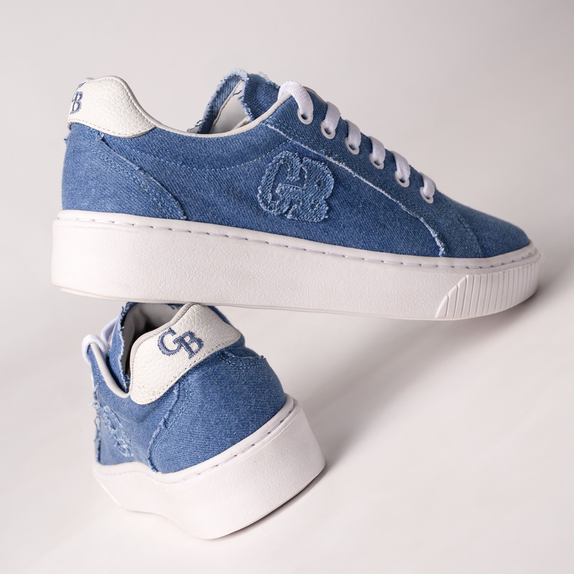 Casual blue denim sneakers with white soles against a white backdrop. Perfect lifestyle footwear.