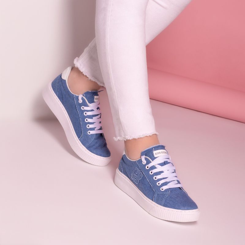 Blue denim sneakers on a pink background