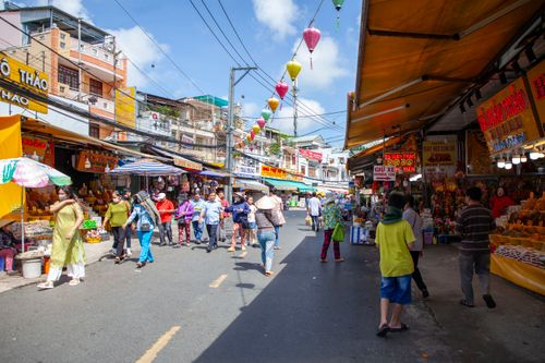 Free A bustling street market filled with diverse people shopping under colorful decorations. Stock Photo