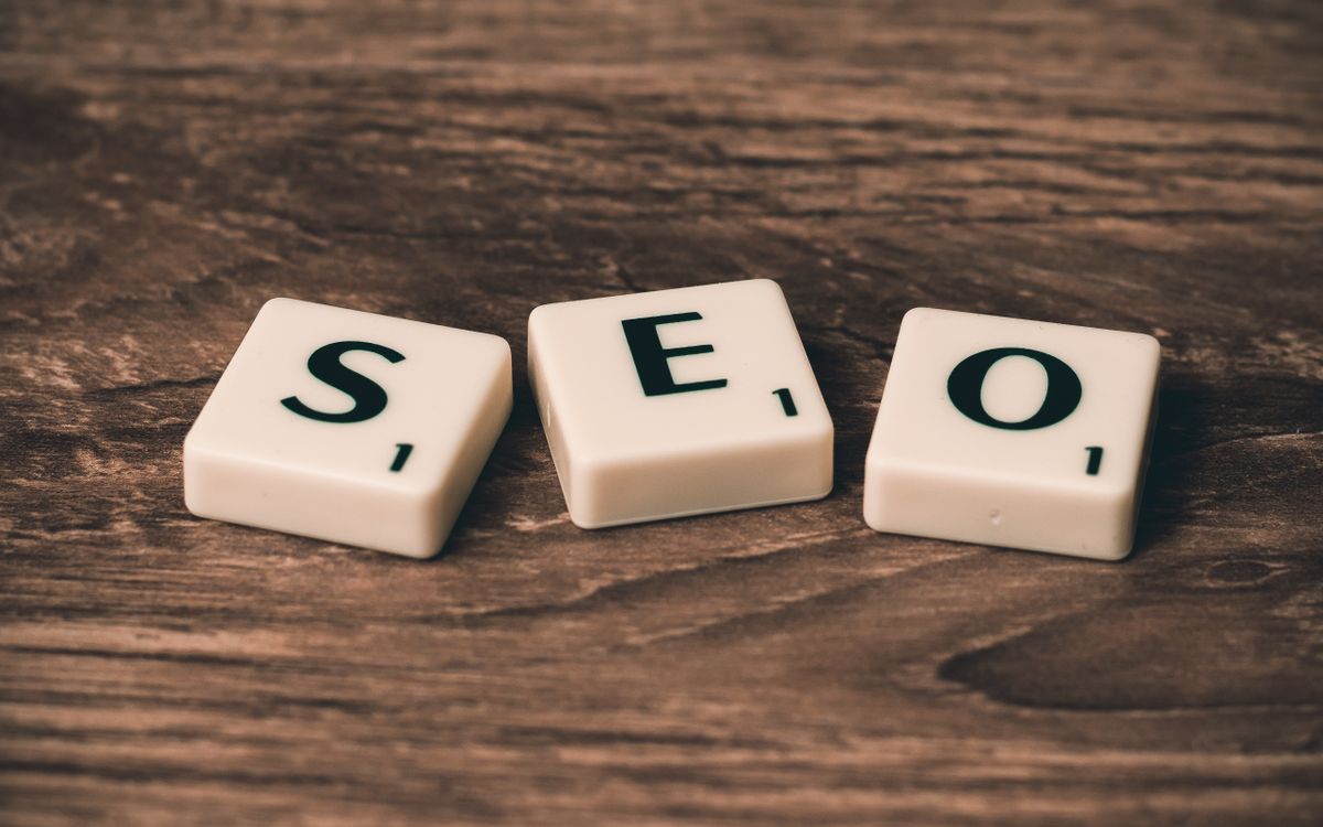 Scrabble tiles spelling 'SEO' on a wooden surface. Ideal for digital marketing themes.