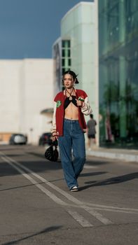 Fashionable young woman walking in city, showcasing modern street style.