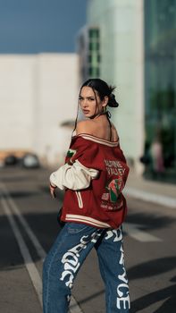 Woman posing outdoors in trendy streetwear with an urban backdrop.