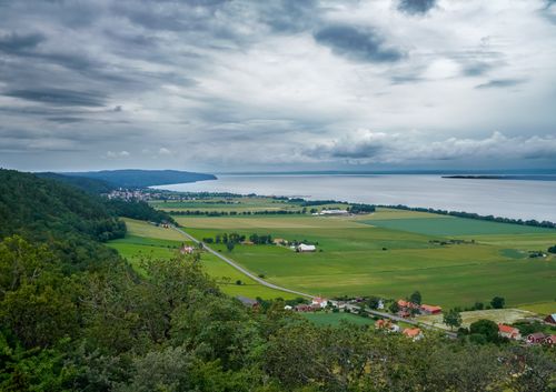 Free Stunning birds eye view of lush coastal farmland and villages by the sea on a cloudy day. Stock Photo