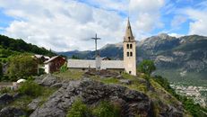 A picturesque church in Puy-Saint-Pierre with the Alps as a backdrop, capturing the serene rural landscape.