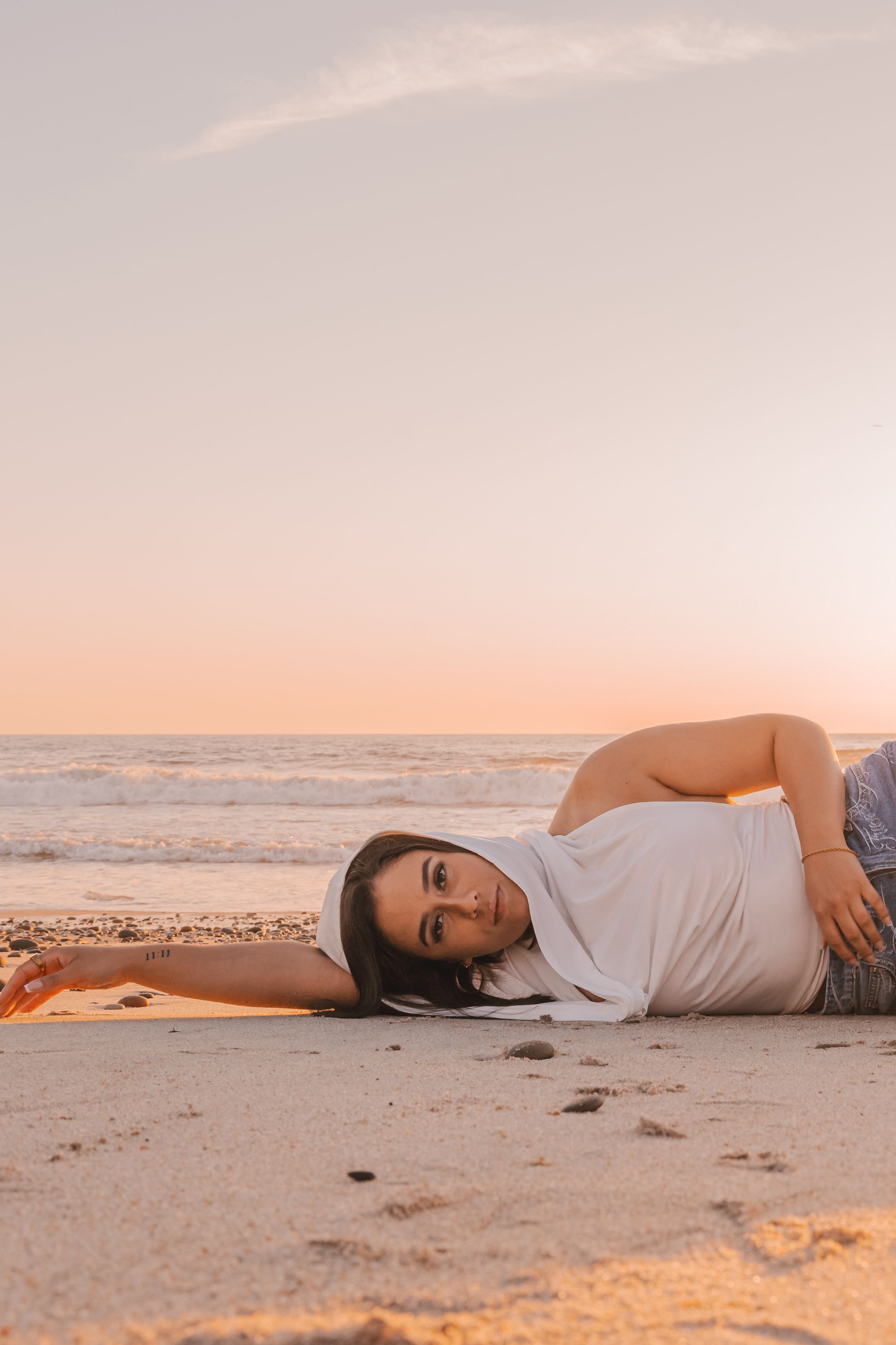 A Young Woman Posing on a Beach at Sunset · Free Stock Photo