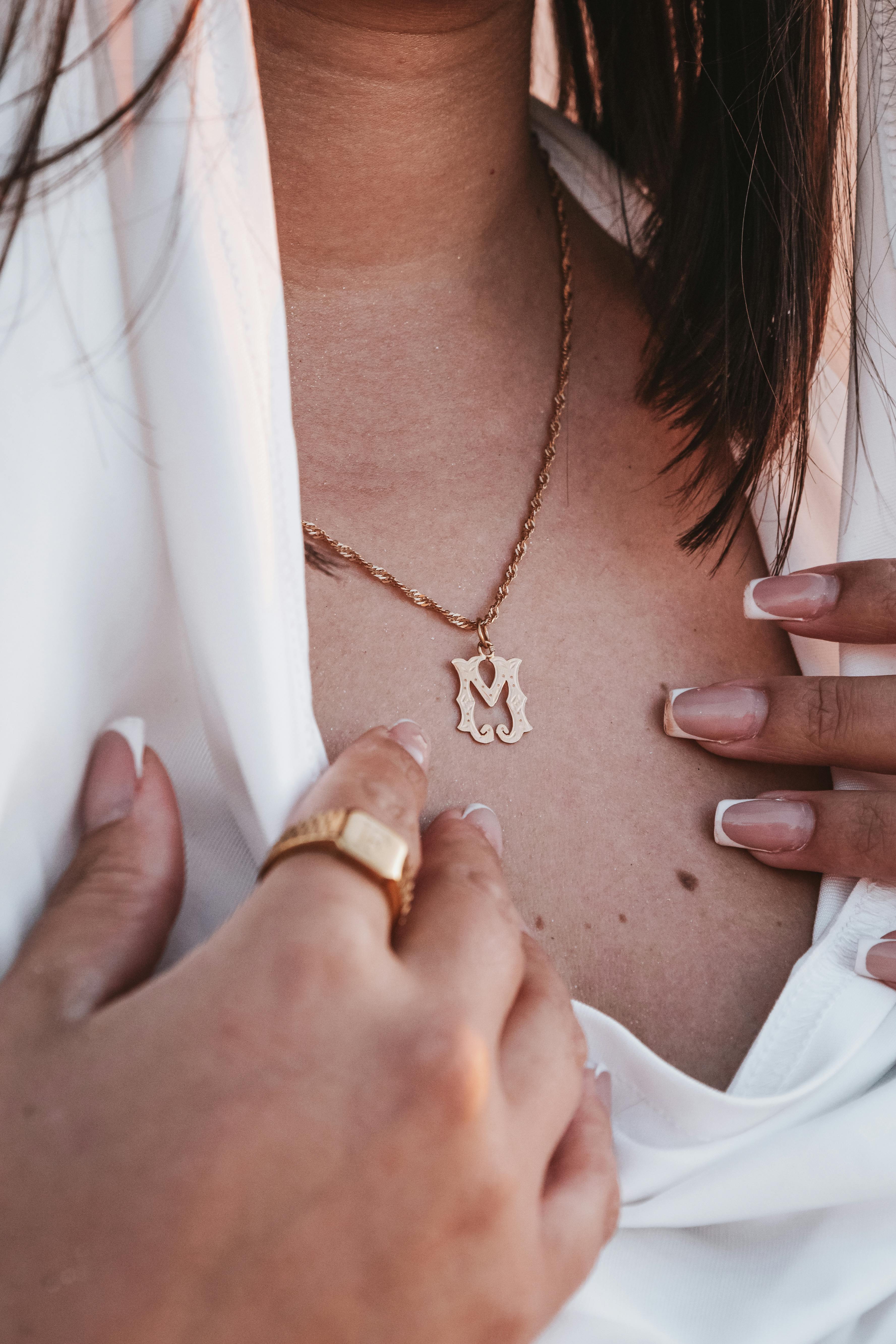 close up of woman necklace and hands