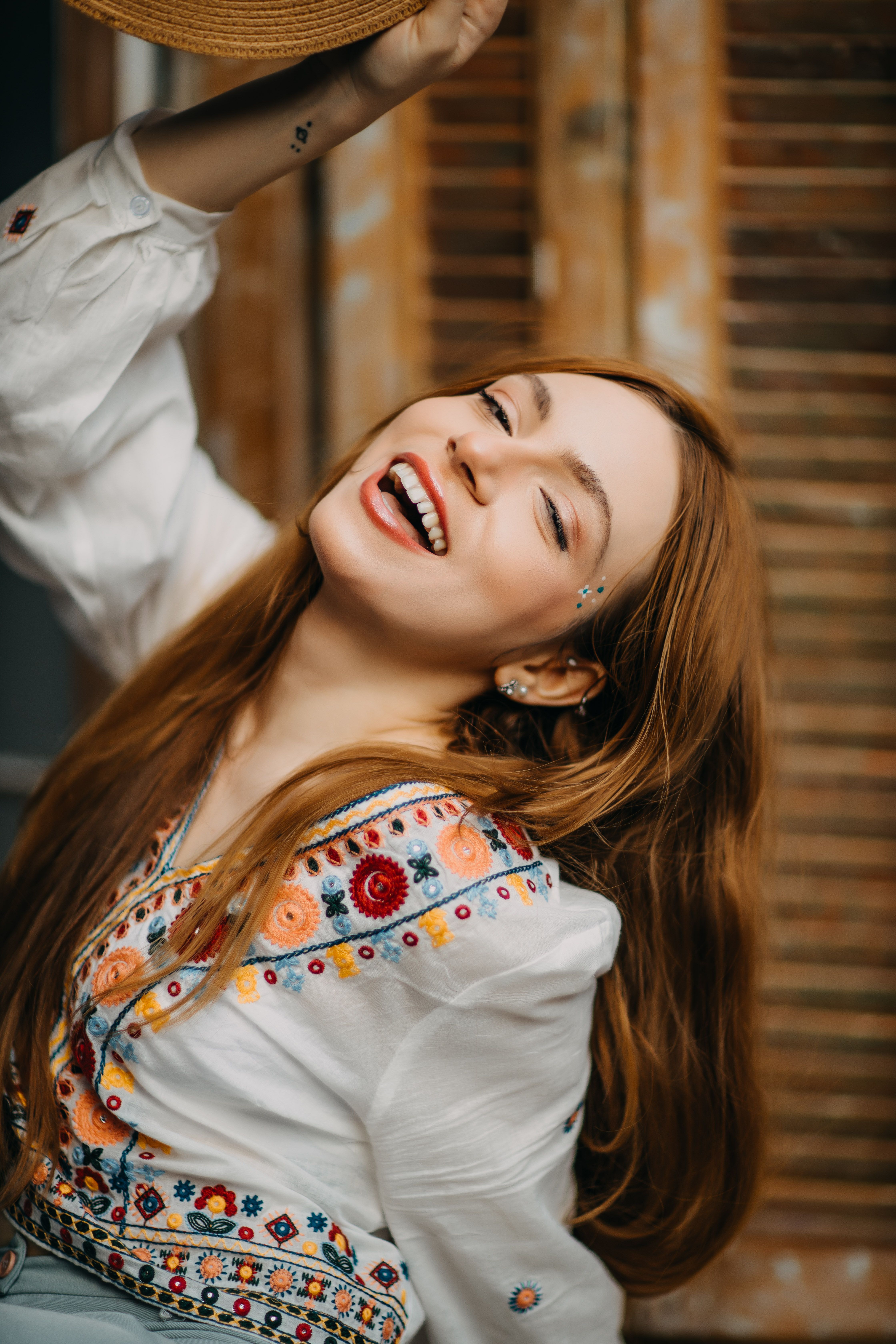 Cheerful woman wearing embroidered blouse, smiling brightly in São Paulo.