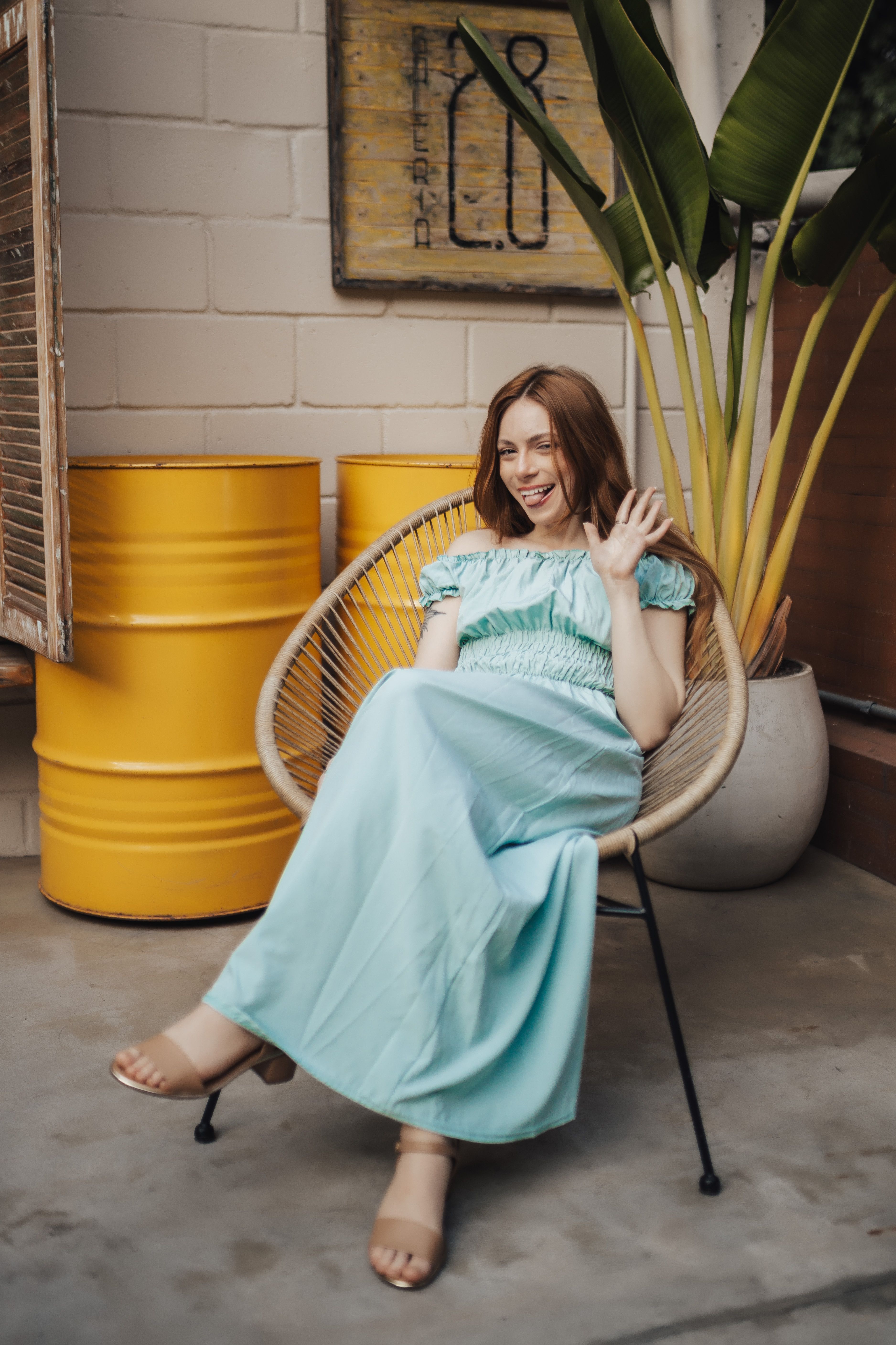 A woman in a blue dress sitting on a chair · Free Stock Photo
