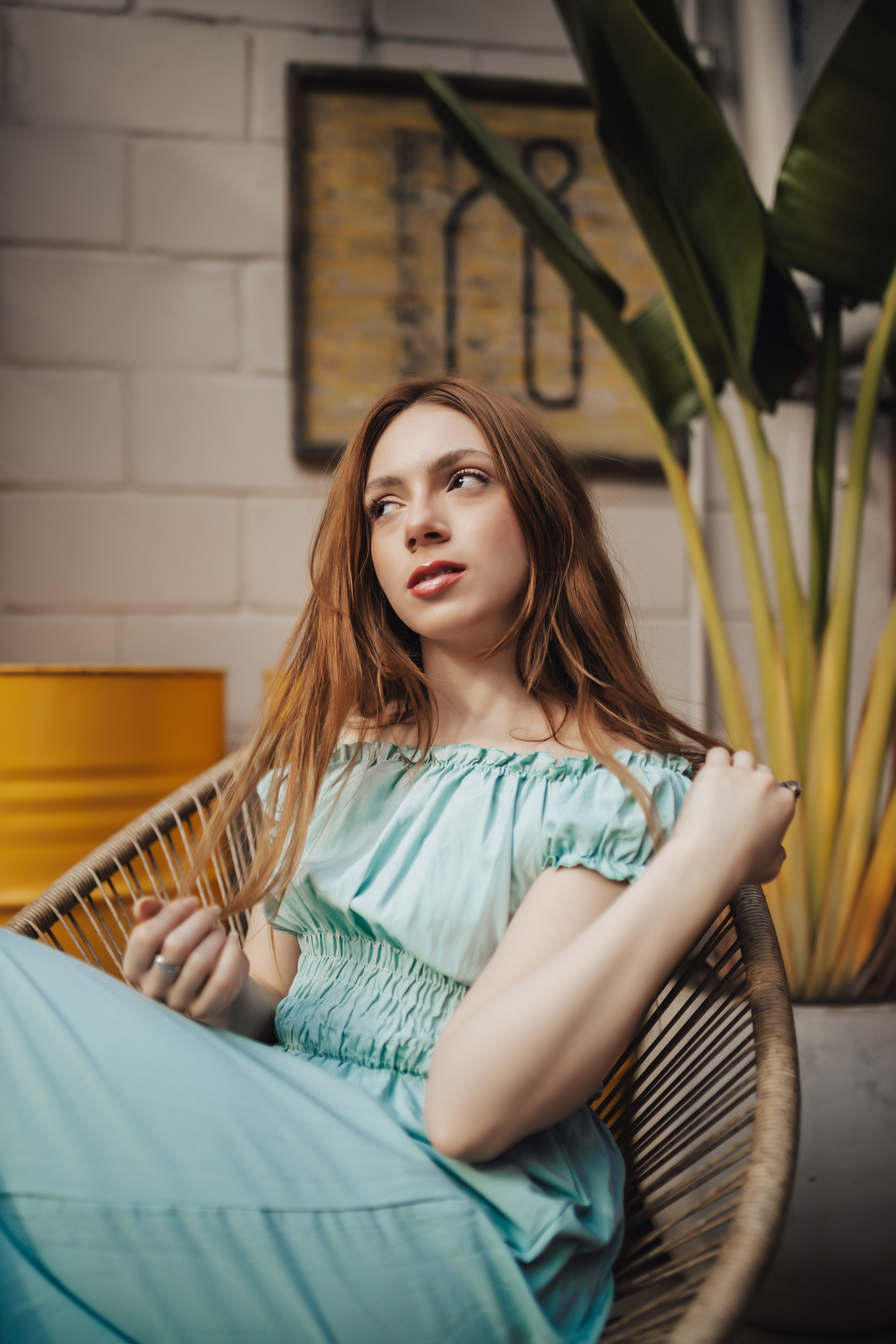 A woman in a blue dress sitting on a chair · Free Stock Photo