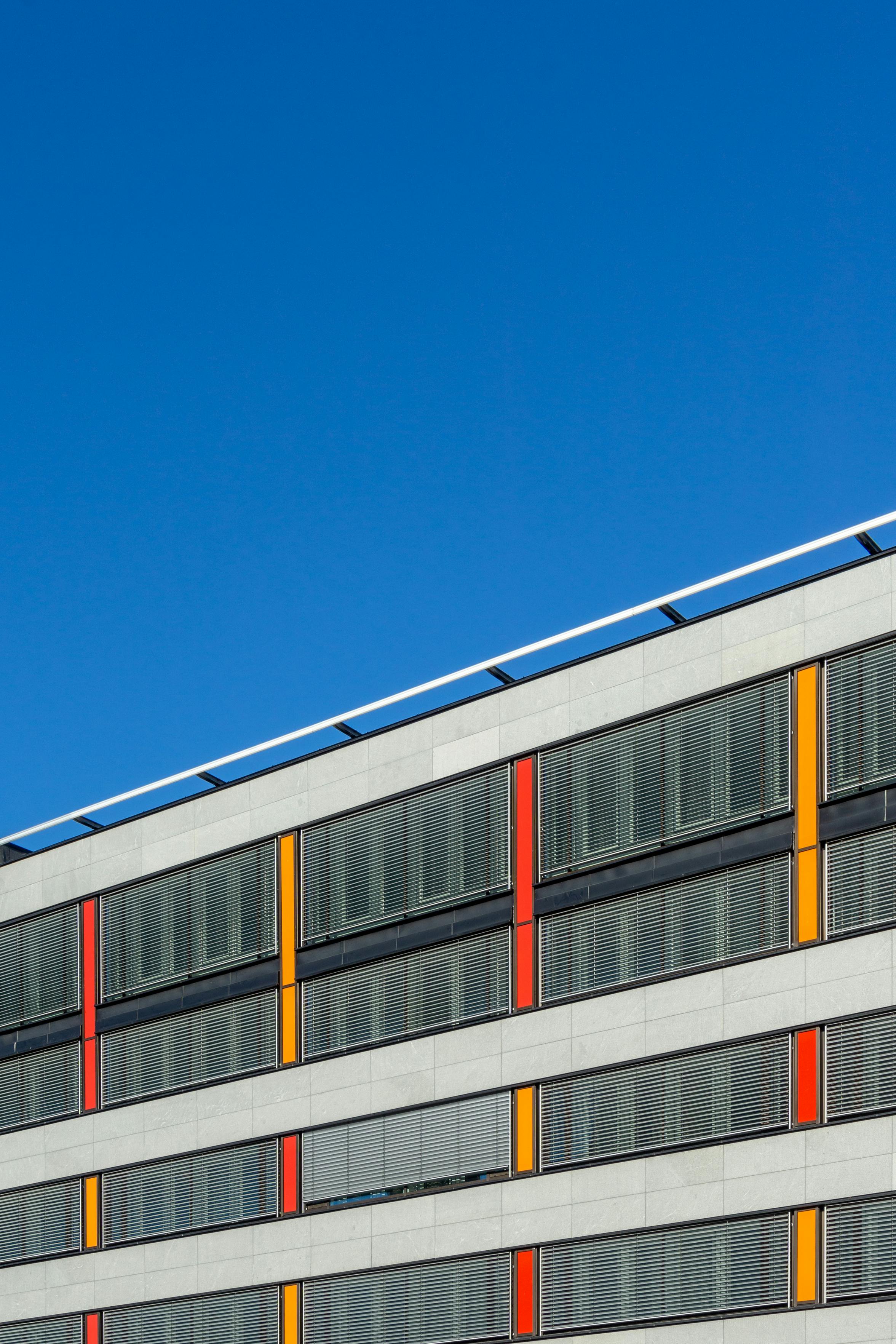 Contemporary office building facade in Oslo with vibrant colors against a clear sky.