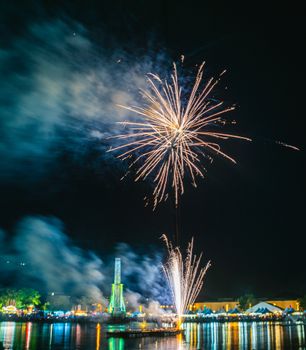 Colorful fireworks light up the night sky over a city waterfront, creating a mesmerizing spectacle.