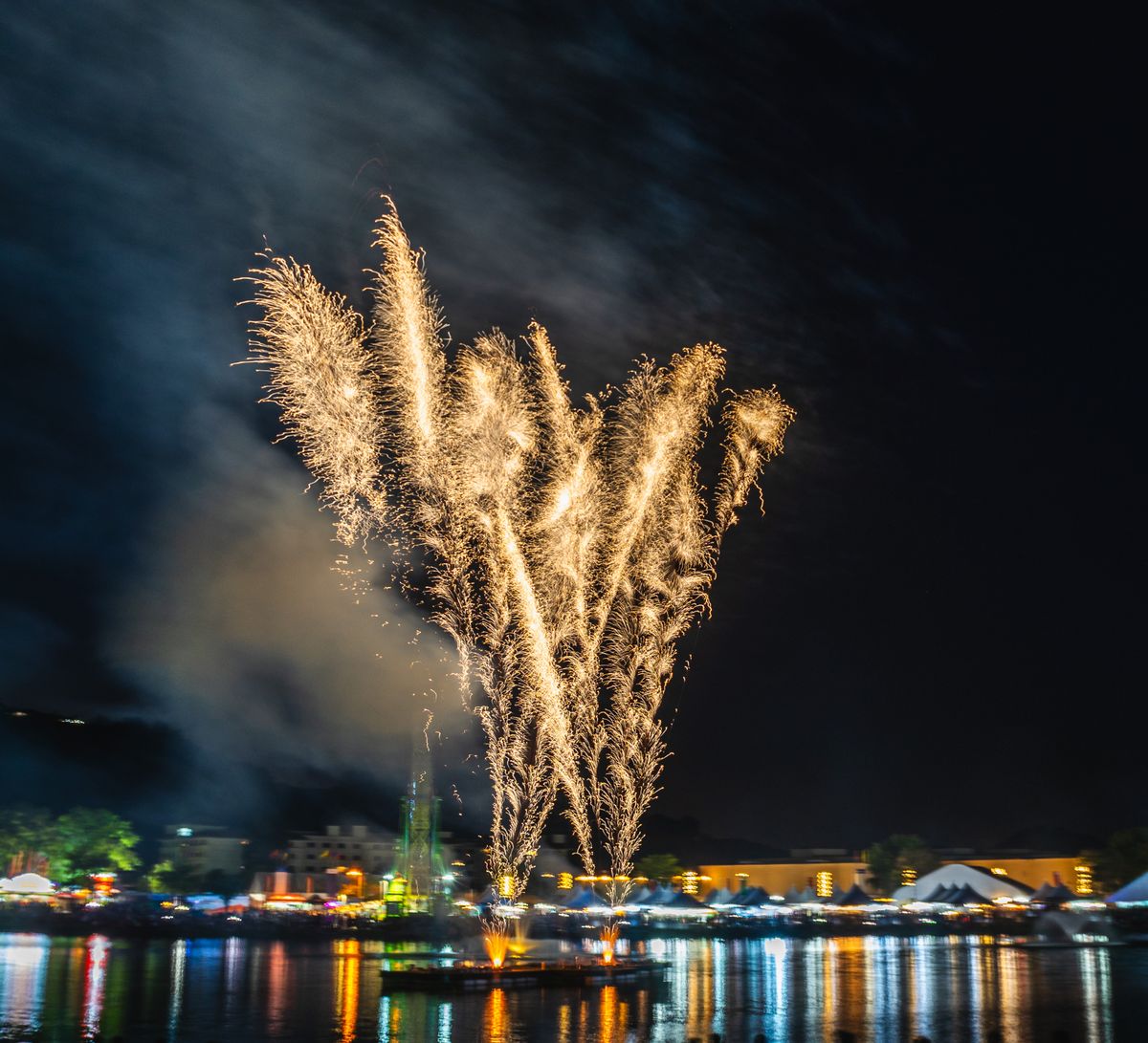Summer fireworks celebration over waterfront lake community