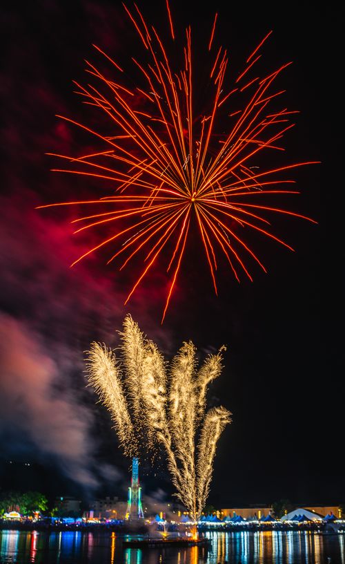 Free Stunning fireworks lighting up the night sky over a waterfront setting, perfect for festive celebrations. Stock Photo