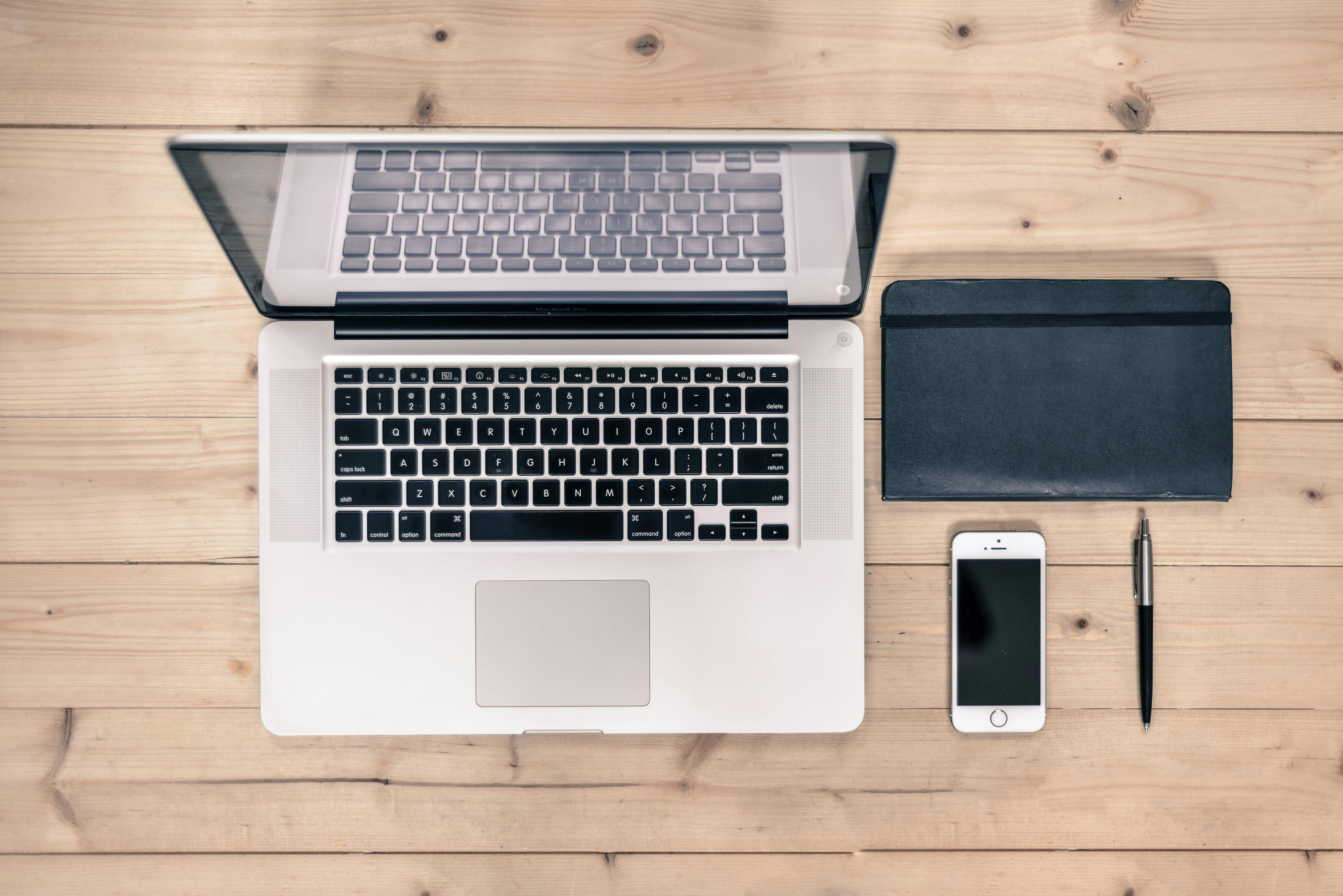 Aerial view of a laptop, diary, pen and mobile phone.