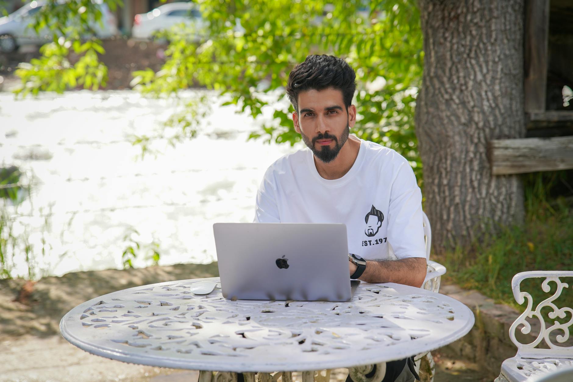 https://www.pexels.com/photo/a-man-sitting-at-a-table-in-a-garden-with-a-laptop-27070513/