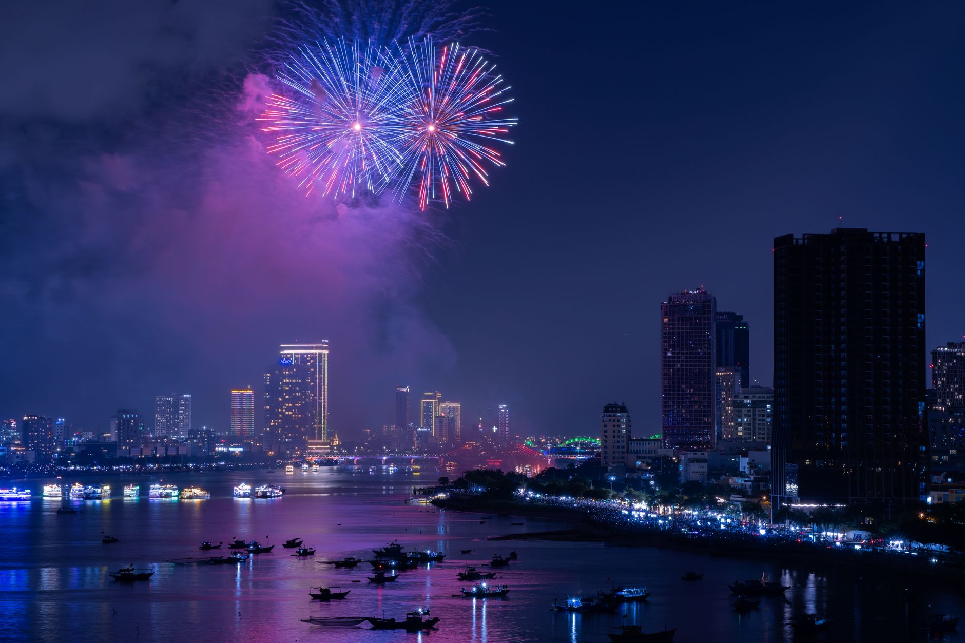 Spectacular view of fireworks illuminating the Hanoi skyline during a city celebration at night.