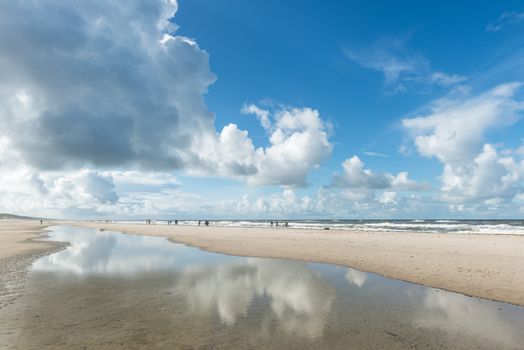 Idyllic beach with dramatic clouds and reflections at Rømø, Denmark.