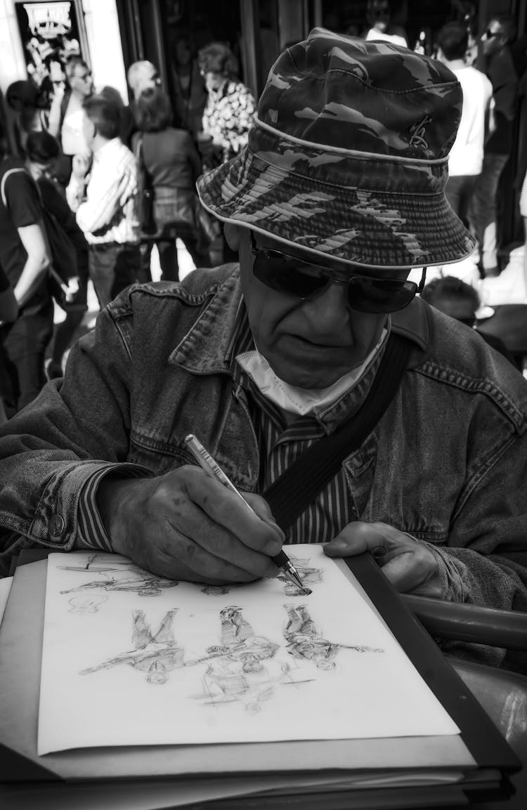 Man In Hat Drawing On Paper