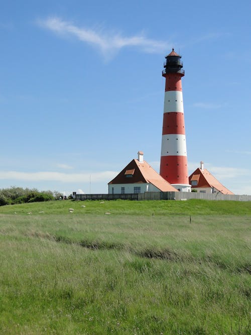 White and Red Lighthouse Near Grass