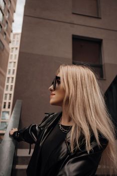 A fashionable woman poses in a stylish urban environment, exuding modern elegance.