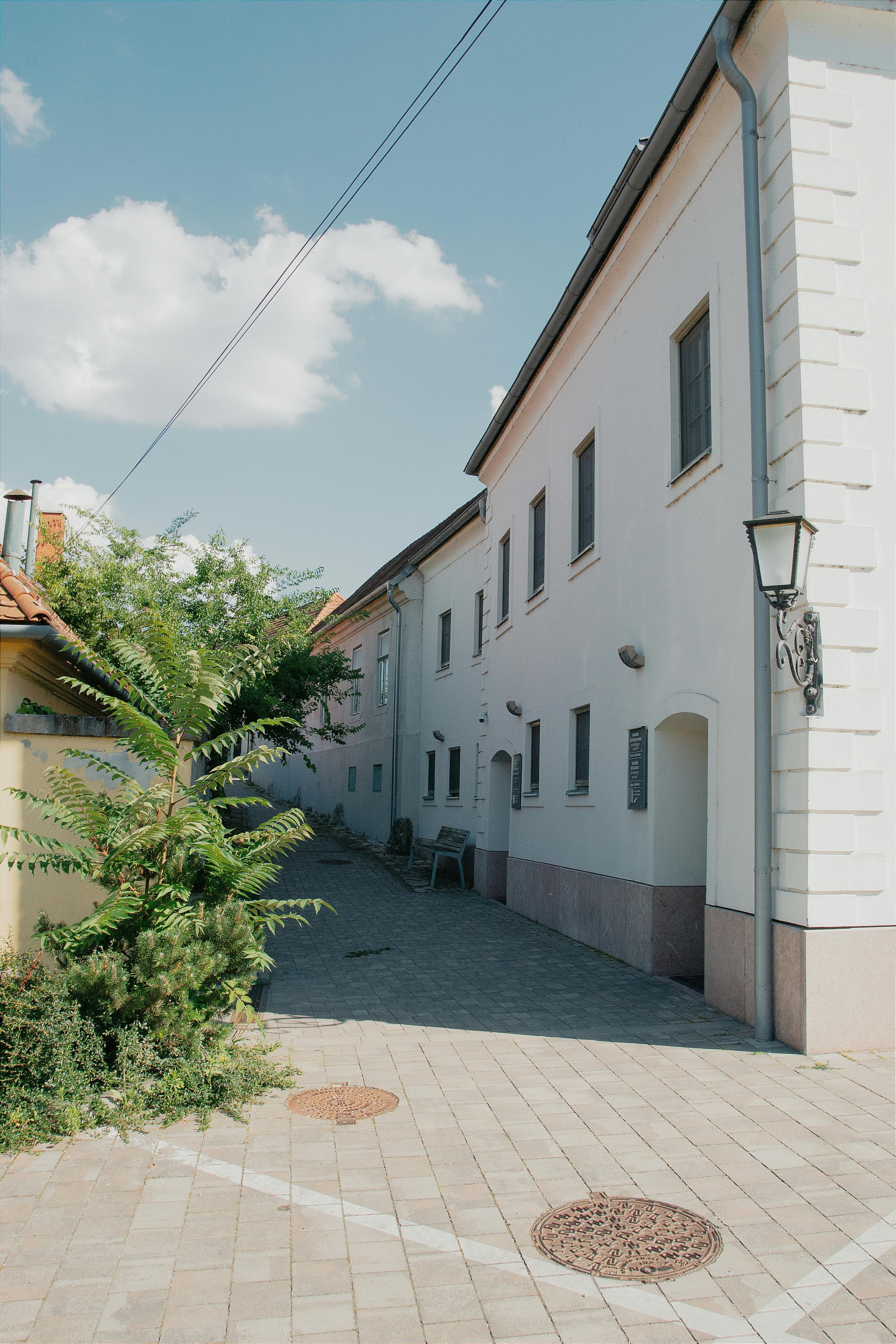 Sunny alleyway showcasing classic European architecture in Hungary.