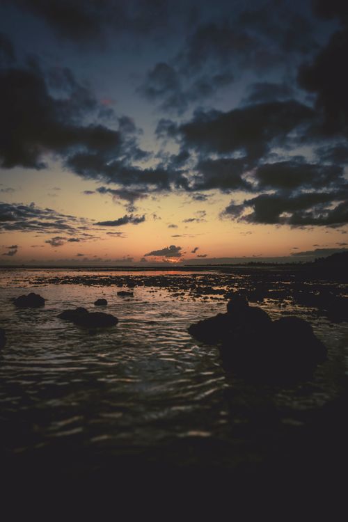 Free A stunning sunset view over the rocky coastline at Pearl Harbor, Hawaii. Stock Photo
