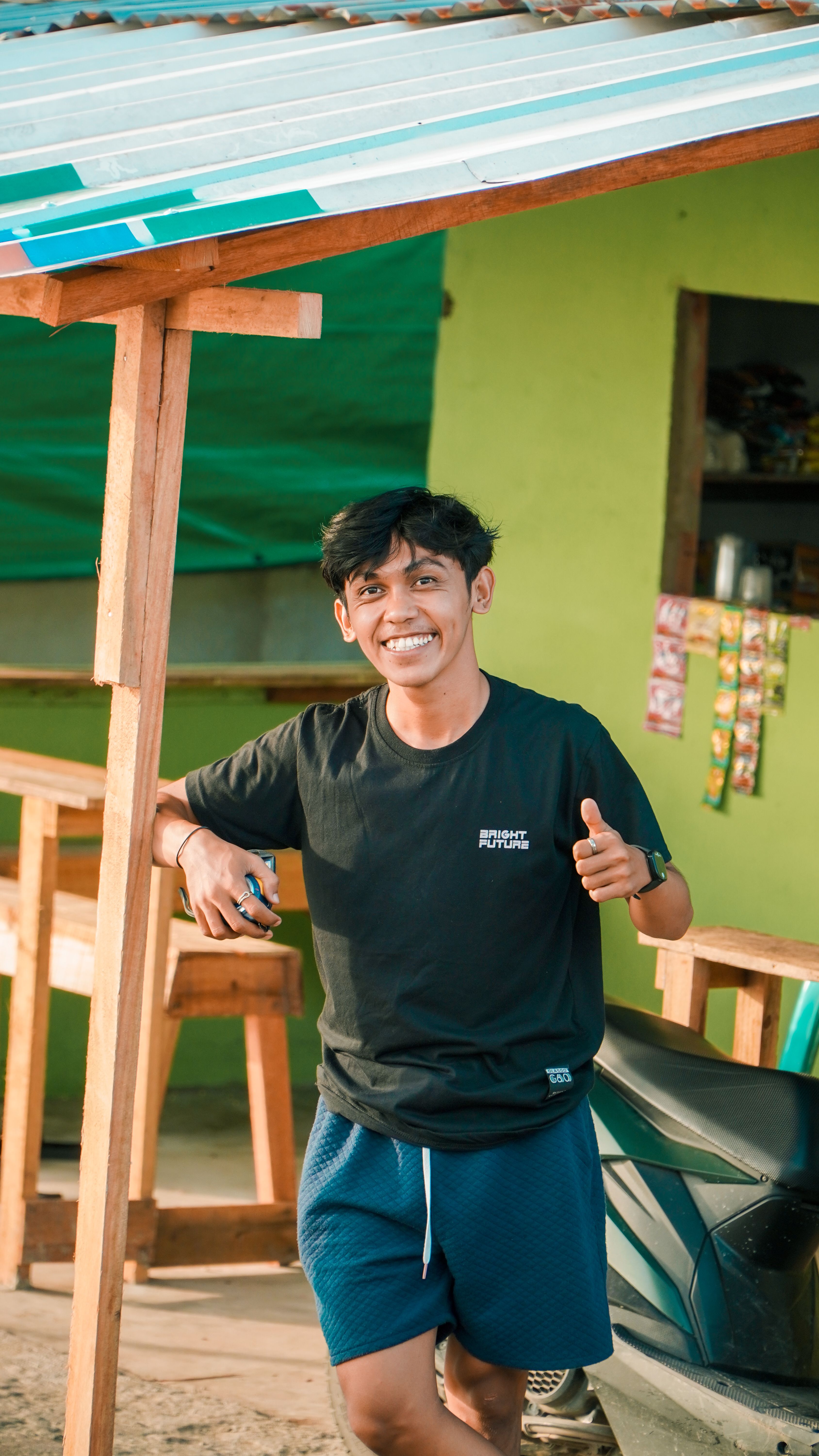 Smiling teenager posing with thumbs up in Pontianak, Indonesia, exuding happiness outdoors.