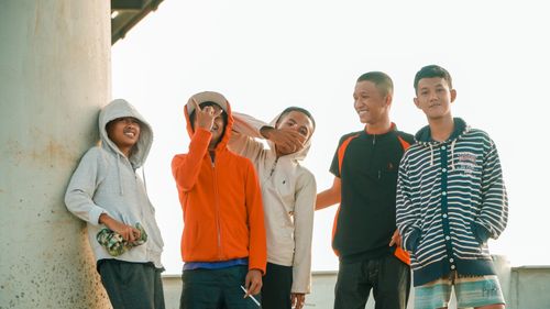 Free Cheerful group of teenage boys in hoodies enjoying a sunny day in Pontianak, Indonesia. Stock Photo