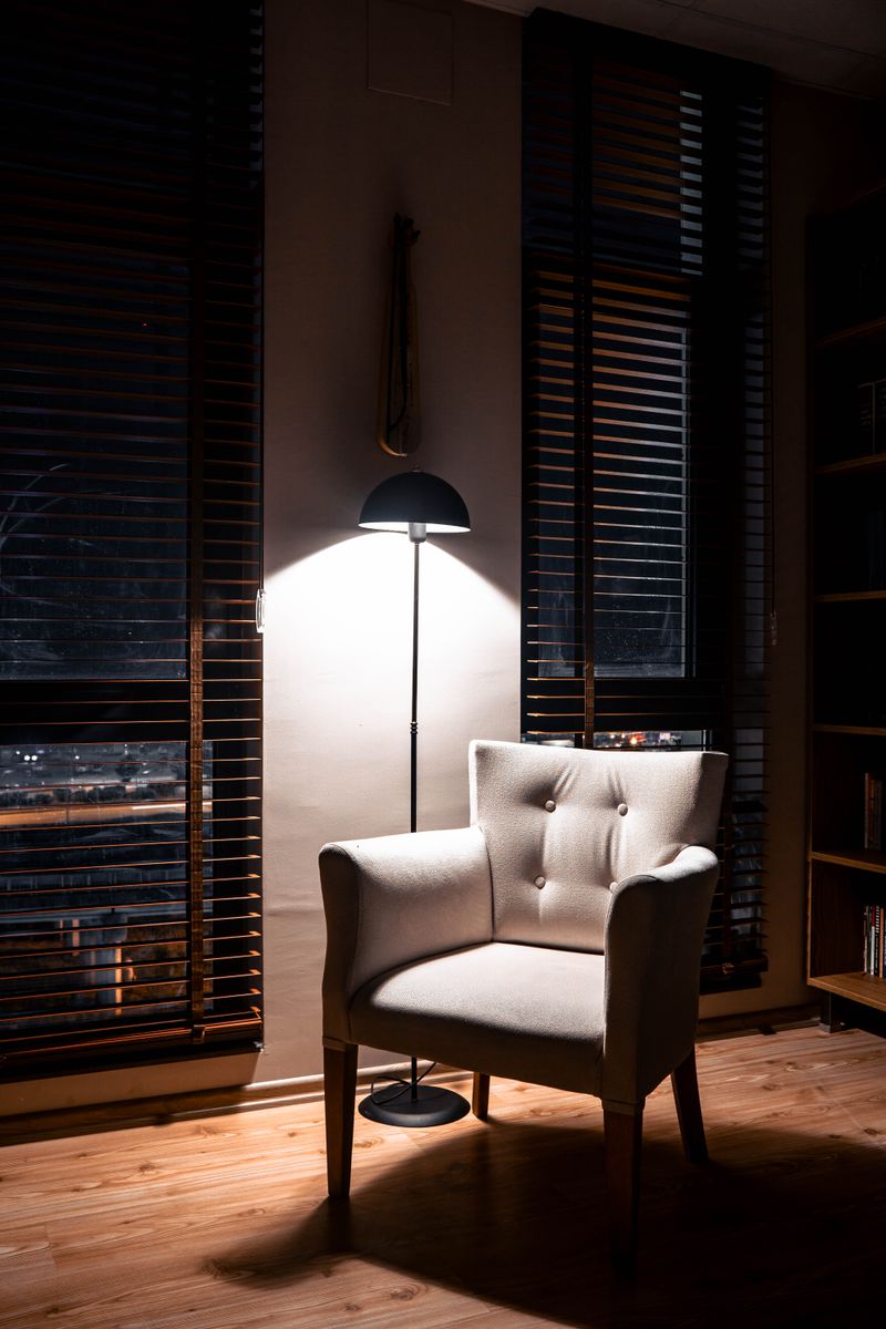 Armchair lit by a floor lamp in a dim room, by Eren Arıcı on Pexels