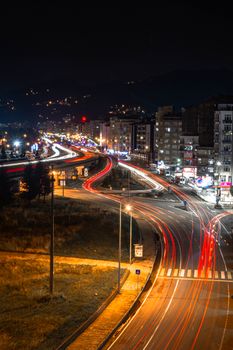 Aerial cityscape at night showcasing vibrant car lights and urban streets in Rize, Turkey.