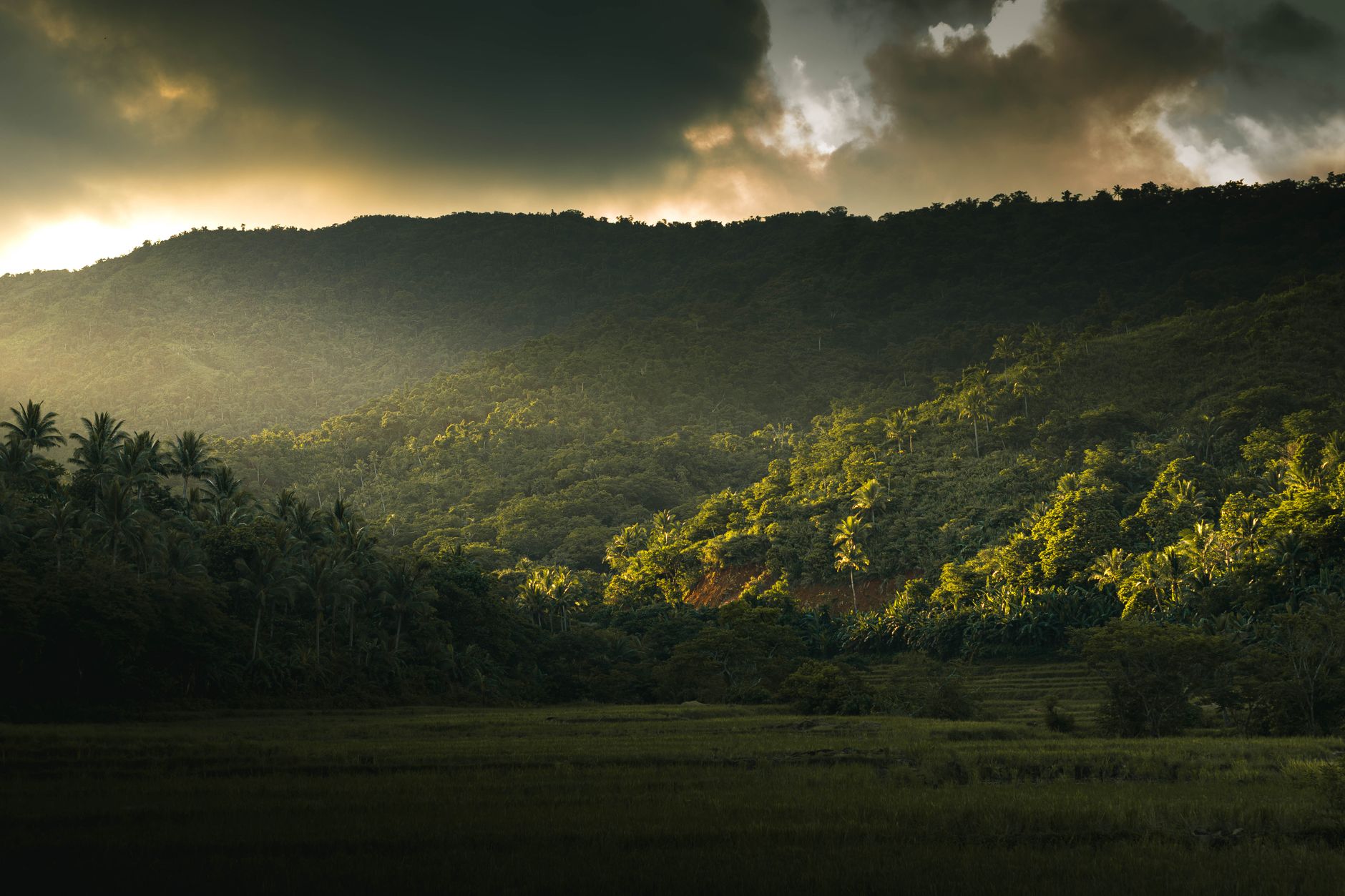 Breathtaking view of Gigmoto's verdant mountain under dramatic sunset clouds.