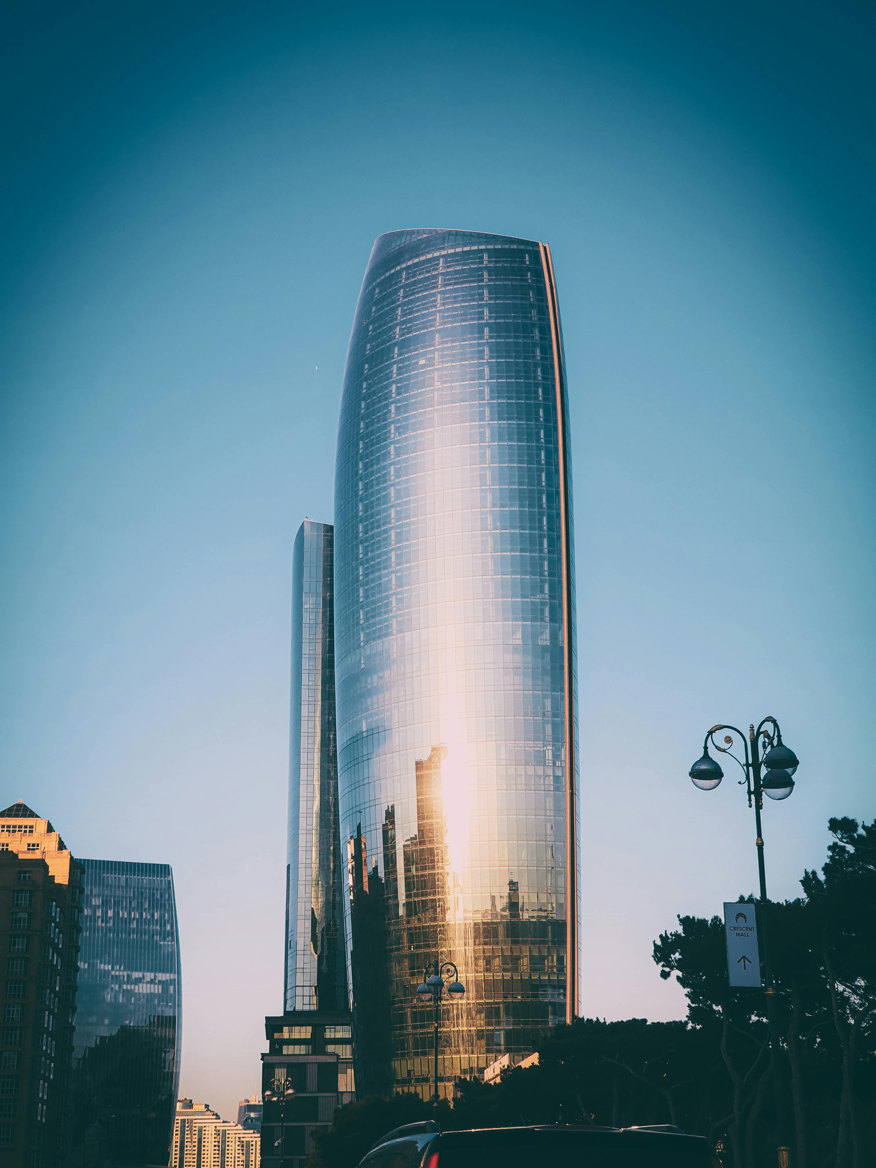 A modern skyscraper with a reflective glass facade in an urban cityscape during the day.