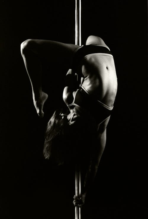 Bezpłatne Fotografia W Skali Szarości Przedstawiająca Kobietę Tańczącą Na Rurze Zdjęcie z galerii