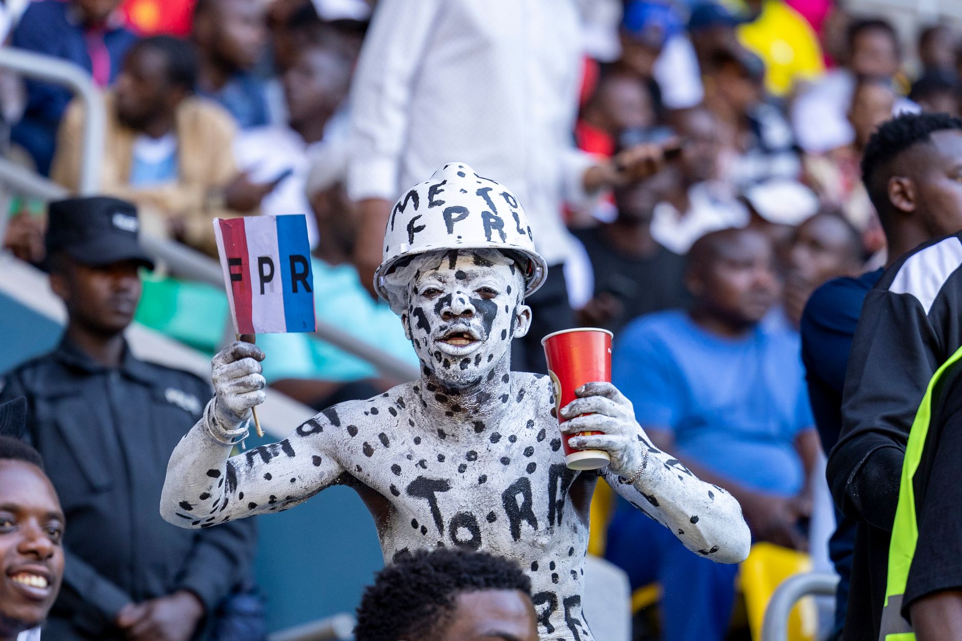 Supporters watching a World Cup match while tactical graphics glow across a large stadium screen