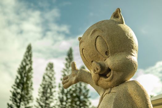 A stone statue of a cartoon character against a sky backdrop in a Gold Coast theme park.