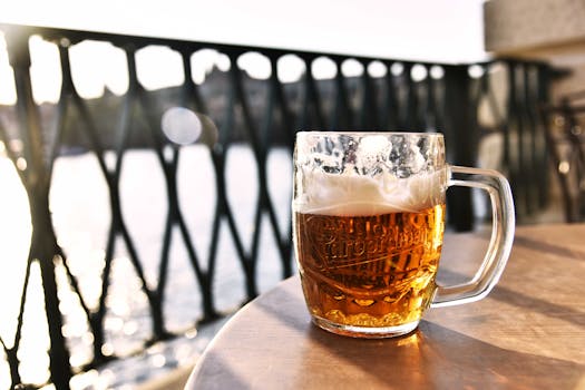 Refreshing lager beer mug outdoors in Prague with scenic river view.