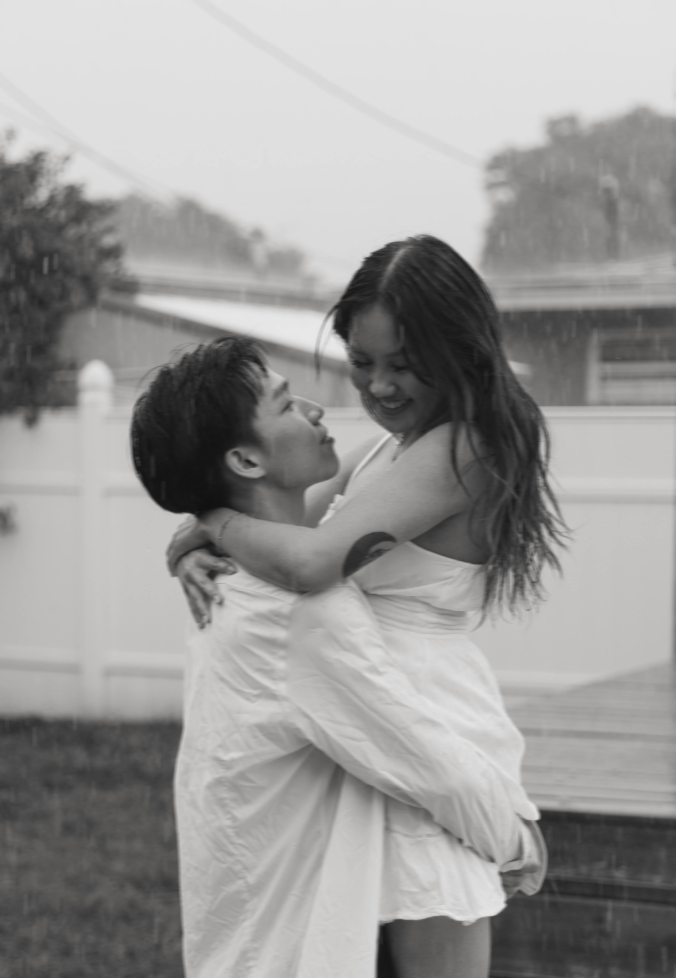 Intimate couple embracing closely, rain adding dreamy moisture to the sensual mood