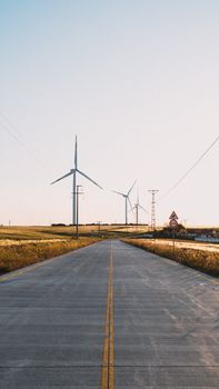 A tranquil rural road in Silivri, Istanbul with wind turbines harnessing clean energy.