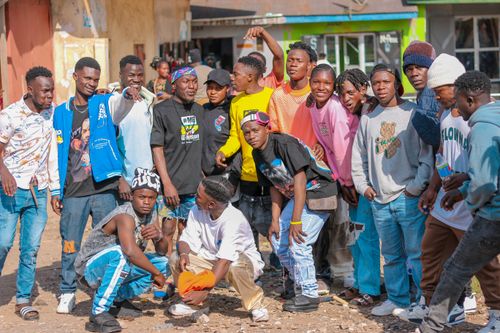 Free A lively group of teenagers posing together outdoors in a village setting. Stock Photo