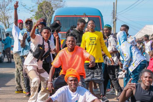 Free Young men gathered outdoors in a vibrant street scene, showcasing energy and camaraderie. Stock Photo