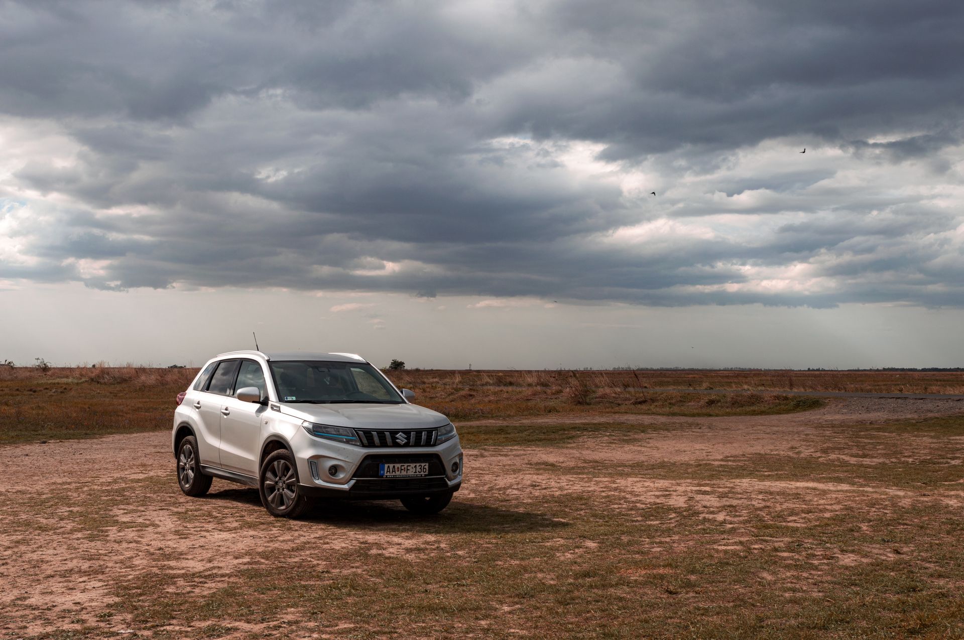 Silver Suzuki SUV on a rural path with dramatic sky — private car transfer in Oaxaca