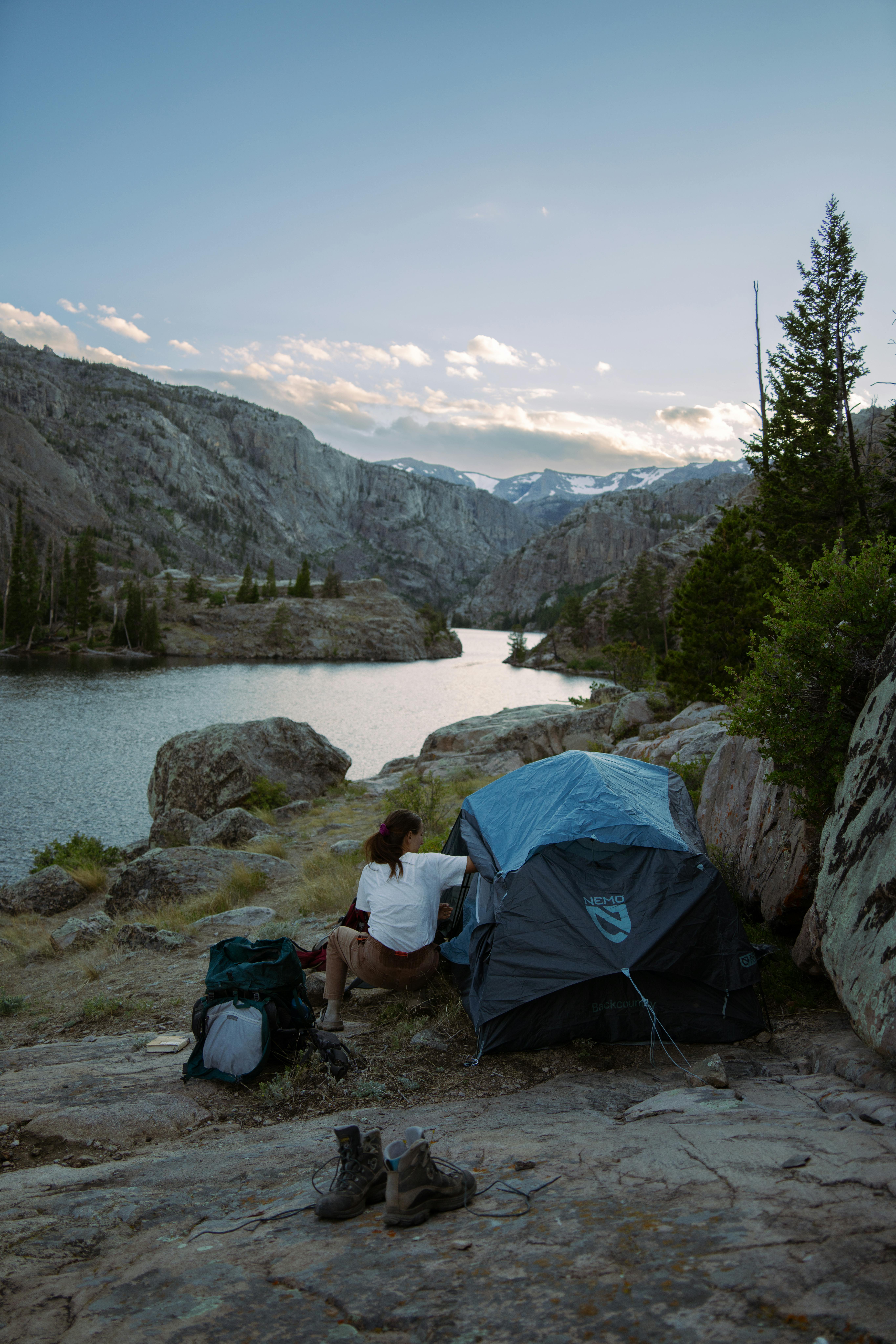 Empty forest campsite with tent near a mountain lake