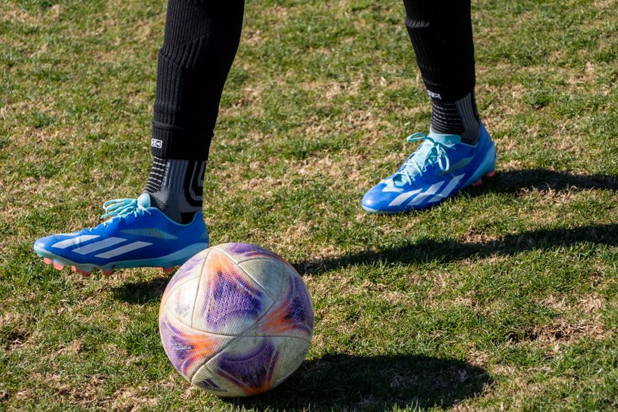 Futbolista con balón y calzado deportivo