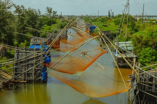 Free A scenic view of traditional fishing nets set over a lush river landscape. Stock Photo