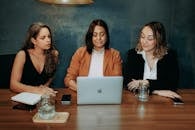 Women Sitting at Table in Cafe with Laptop Working Together